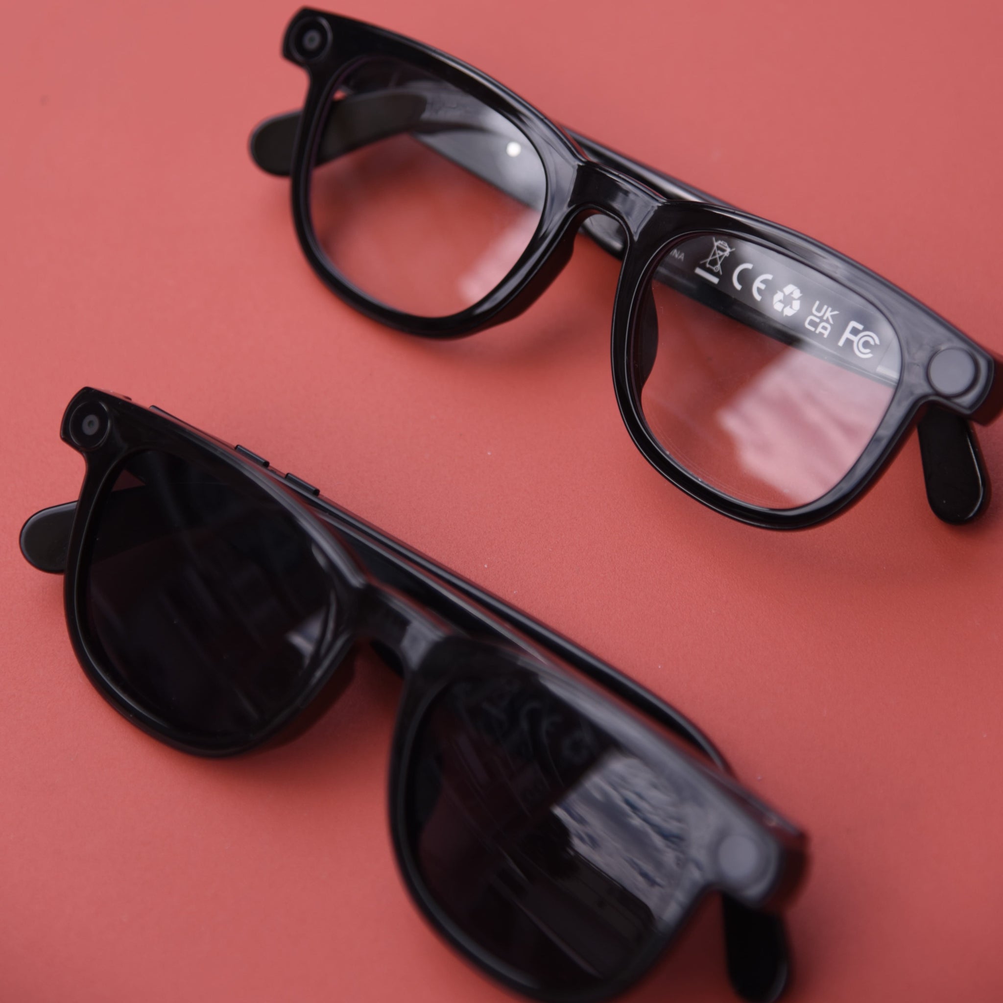 Black glasses with a clear lens on a red background